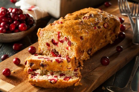 Cranberry Bread with fresh cranberries scattered about.