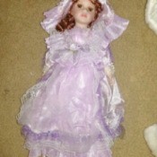 Identifying and Determining Value of Porcelain Dolls - red haired doll wearing a lavender dress