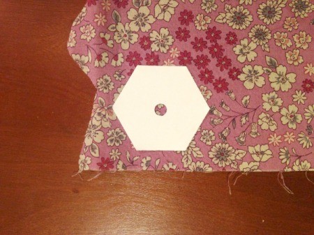 English Paper Pieced Hexagons - place template on fabric leaving room to cut around with a 1/4 inch allowance.