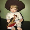 Value of Porcelain Dolls - boy child doll wearing a very large cowboy hat