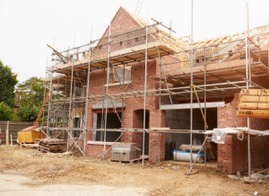 Brick house surrounded with scaffolding.