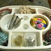 An old Tupperware container with several sections filled with jewelry findings.