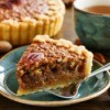 Slice of pecan pie on a green plate.