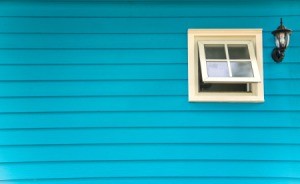 Freshly painted blue house with 1 white window.