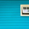 Freshly painted blue house with 1 white window.