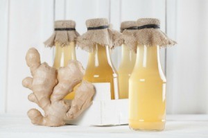 Ginger Syrup in bottles with piece of ginger.