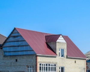 Brick house with maroon tin roof.
