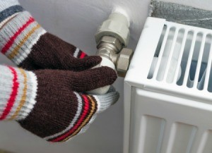 Gloved hands adjusting thermostat