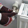 Gloved hands adjusting thermostat