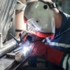 Man welding pipes together