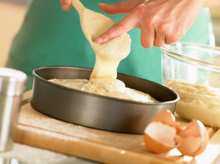 Woman pouring cake batter into pan