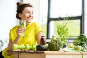 Woman drinking water at table with healthy foods