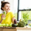 Woman drinking water at table with healthy foods