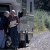 Elderly couple outside their RV looking at a map