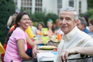 Man at his Retirement Luncheon with woman smiling in background