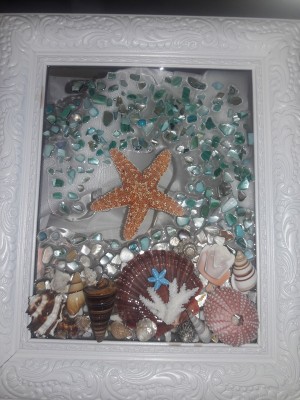 A frame with shells and glass to make a seascape.