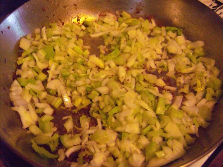 Adding chopped garlic, onions and celery to skillet