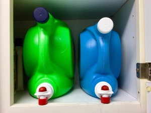 Laundry detergent and fabric softener dispensers with lids attached.
