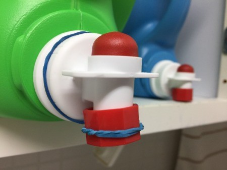 Laundry detergent and fabric softener dispensers with lids attached.