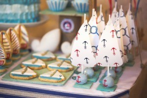 Ship Shaped cookies and sailboat cake pops on a table ready for party