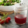 Raspberry Vinaigrette in mason jar with whisk, fresh raspberries and a salad