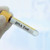 DNA test tube being held in gloved hand