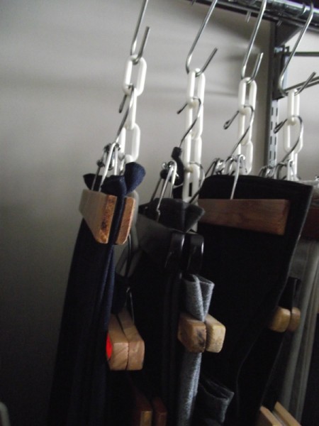 Clothes hanging from chains in the closet.