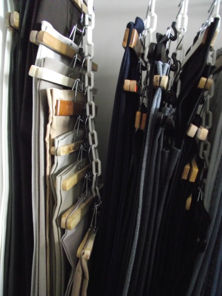 Clothes hanging from chains in the closet.