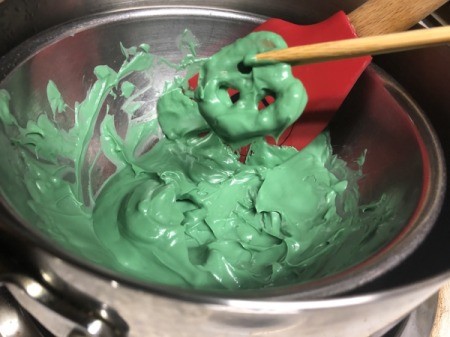 dipping pretzels in melted candy