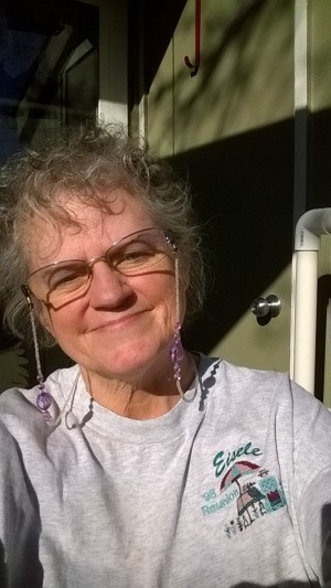 A woman standing outside a home and smiling.