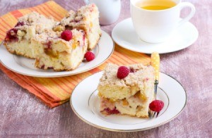 Slice of apple raspberry crumb cake on a white plate.