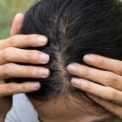 Woman showing her grey roots in her hair.
