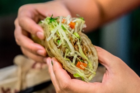 A person holding a taco, ready to eat.