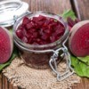 Pickled beets in a jar with a halved beet on the side