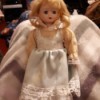 Identifying a Porcelain Doll - blond doll with white pinafore over pinkish blouse