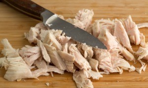 Leftover Turkey cut up into pieces on cutting board with knife