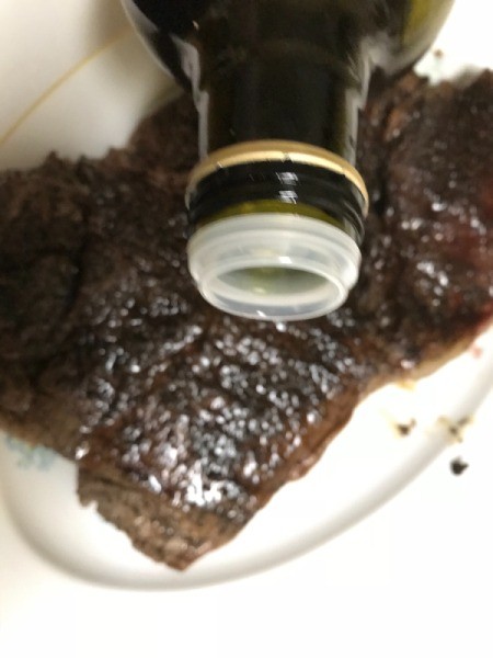 adding olive oil to steak