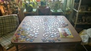 A jigsaw puzzle being worked on a card table.