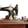 Antique sewing machine on a sewing table with thread.
