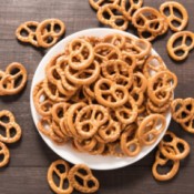 A batch of small pretzels in a white bowl.