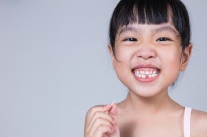 Young girl holding her extracted tooth.