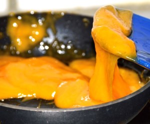 Melted cheese in a pan for topping a burger.