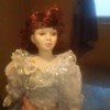 Identifying a Porcelain Doll - dark photo of a doll wearing a fancy dress with ruffled collar