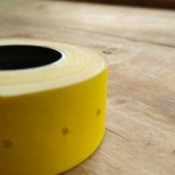 Roll of tape on a piece of wood.