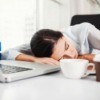 Woman sleeping at her work desk.