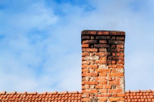 Brick chimney with black soot on the top.