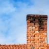 Brick chimney with black soot on the top.