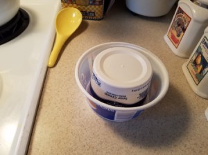 One small plastic container upended inside another.