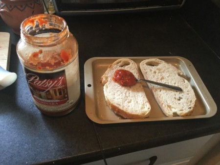 adding sauce to Bread Pizzas