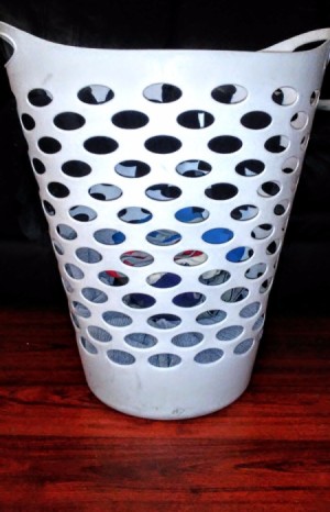 A laundry basket with holes in the side.